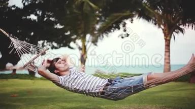 年轻的帅哥在美丽的热带海滩上的吊床上放松。 假期概念。 <strong>1920</strong>x1080